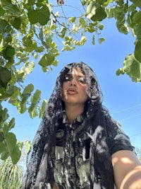 a woman wearing a black scarf in a tree