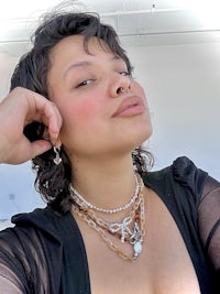 a woman is posing for a photo wearing a necklace