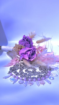 a bouquet of purple flowers and a necklace on a table