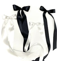 three black and white satin bows on a white surface