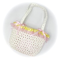 a white crocheted bag with pink and yellow ribbons